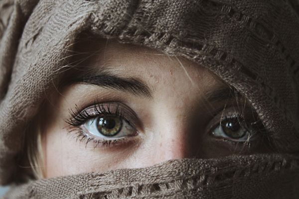 Woman with material over her face only showing her eyes.